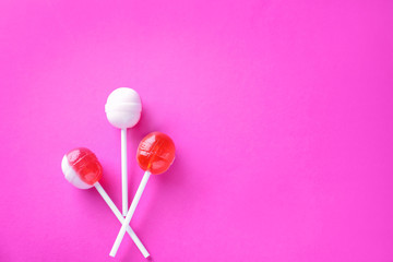 Delicious lollipops on color background