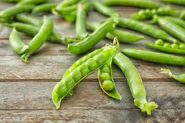 Delicious fresh green peas on wooden background