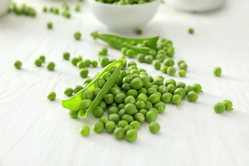 Delicious fresh green peas on white wooden background