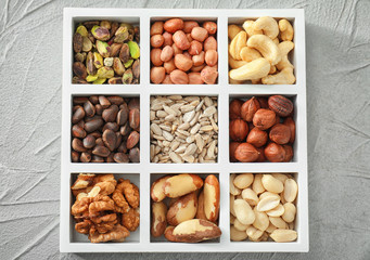Box with different nuts on textured background