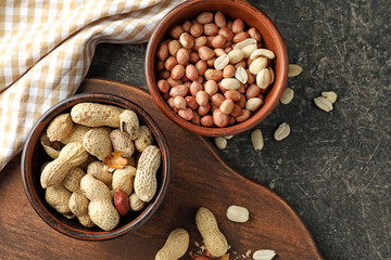 Bowls with tasty peanuts on table