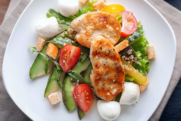 Tasty salad with chicken, vegetables and mozzarella cheese on plate, closeup