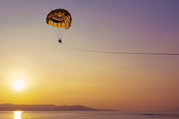 Couple parasailing at sunset in Makarska, Croatia
