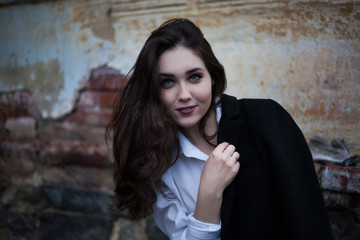 Dark-haired girl in a black coat on her shoulders
