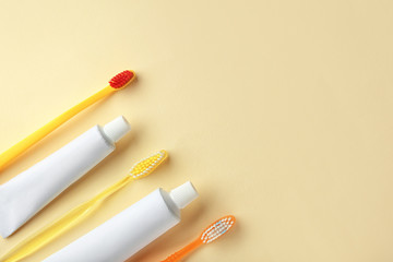 Toothbrushes and paste on color background