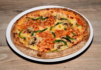 Whole round pizza topped with cheese, tomato, green peppers, mushrooms and baked beans.