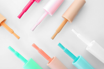 Brushes with colorful nail polishes on white background