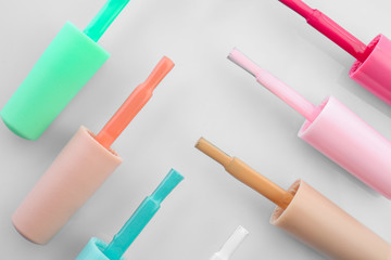 Brushes with colorful nail polishes on white background