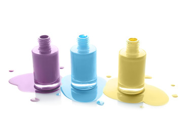 Open bottles of nail polishes on white background