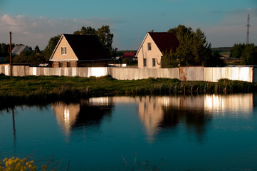 Fototapeta na wymiar two houses cottages on the river bank