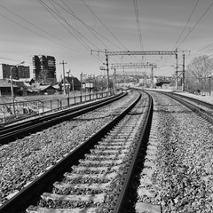 Railway tracks in front of the station, Prague. High contrast, black and white image. Electrical wires on supports