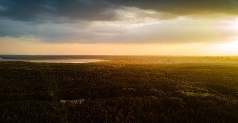 Aerial drone view of residential area with huge city forest, capital of South Ural in sunny evening after rain, park of culture and recreation on the foreground, Russia