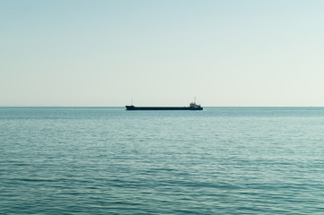 Obraz premium Large ship in the middle of the sea near the coast leading towards the port.