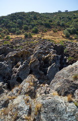 Fototapeta na wymiar The eroded schists form sharp blades and deep drops in the rocks. Pulo do Lobo. Alentejo, Portugal.