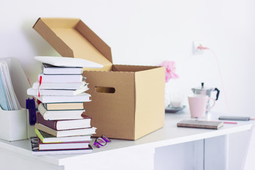 table with stationery, unpacking box with books. girl Back to college. Coffee, flowers, notebook