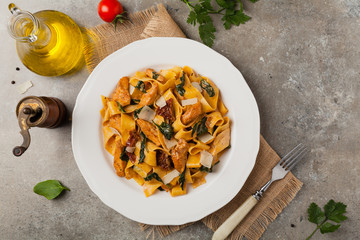 Italian salad, pappardelle pasta, with spinach, grilled chicken and dried tomatoes, sprinkled with flakes of cheese.