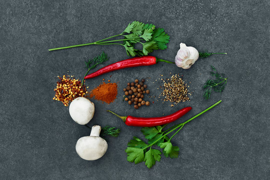  Various herbs and spices on black background.  Pepper, Salt, Red chilli, garlic,turmeric, pepper peas. Top view  copy space.