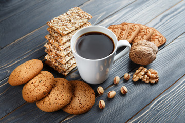 Cup of hot coffee assorted with cookies for breakfast on wooden vintage gray table.