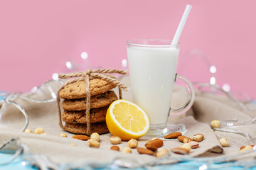 Cookies and glass with milk on rustic wooden blue and pink background.