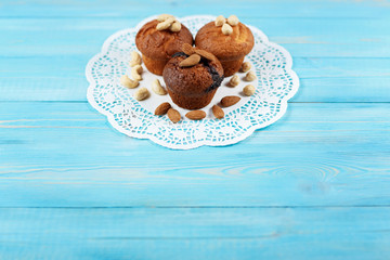 Delicious homemade chocolate muffins on the blue vintage wooden background.