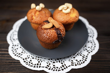 Delicious homemade chocolate muffins on the vintage wooden background.