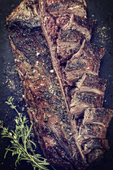 Traditional barbecue aged saddle of venison marinated as top view on an old rustic board vintage style