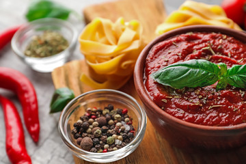 Bowl with spicy tomato sauce on table, closeup