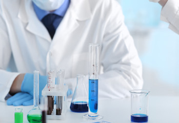 Scientist with test glassware in laboratory