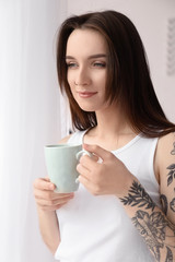 Young beautiful woman drinking coffee at home in morning