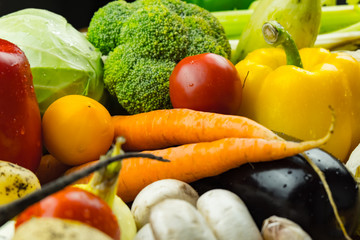 Close-up image of fresh organic vegetables. Locally grown bell pepper, corn, carrot, mushrooms and other natural vegan food laying on table.