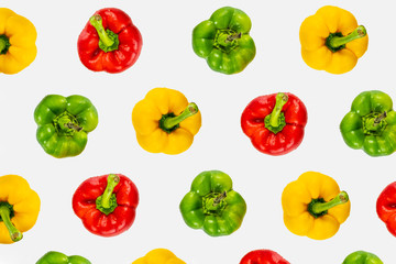 Top view pattern of fresh bright bell peppers on white background. Shot from above of multiple colorful paprika vegetables
