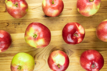 Top view pattern of fresh red apples on rustic wood background. Shot from above of multiple home grown apples on table