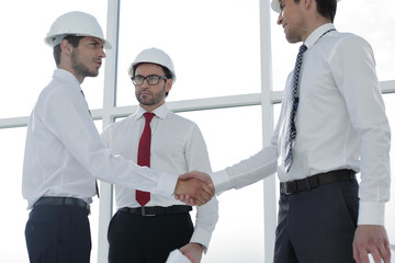 Two architects shaking hands after a meeting in office