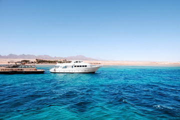 Beautiful white yacht near tropical resort on sunny day