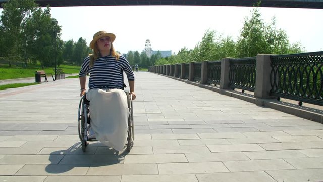 The invalid woman sit and ride in the wheel chair on the waterfront