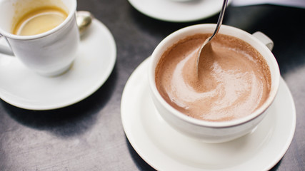 Hot chocolate being stirred with a spoon - 214741989
