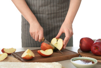 Woman cutting apples for pastry on wooden board
