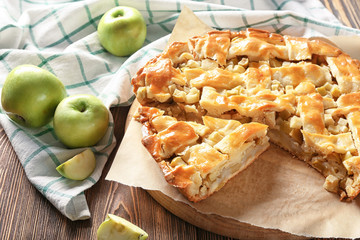 Fresh apples with tasty homemade pie on wooden table
