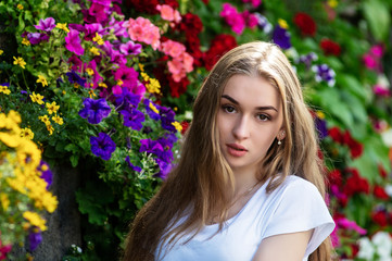 Naklejka premium Portrait of a young girl in a circle of flowers.
