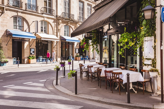 Fototapeta Cozy street with tables of cafe  in Paris, France