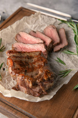 Board with tasty grilled steak on table