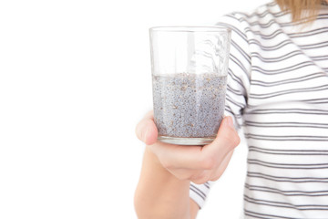 Hand of asian woman holding glass of chia seeds soaking in water isolated on white background. Free from copy space.