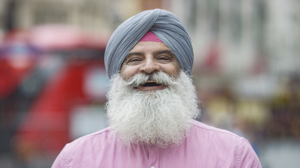 Portrait of senior Indian man in a turban smiling to camera on the street