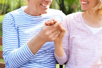 Mature couple resting in park on spring day, closeup