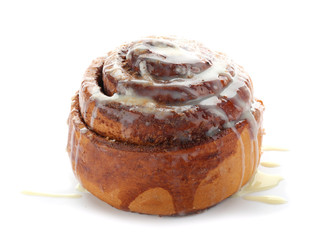 Tasty homemade cinnamon bun with glaze on white background