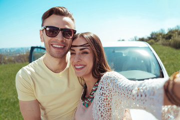 Smiling girlfriend. Smiling girlfriend wearing stylish accessories making photo with her handsome...