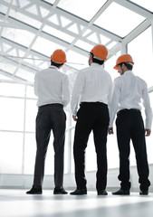 rear view.three architects standing in the new building