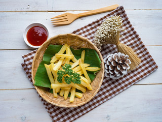French fried original flavour in wood basket on white wood table.