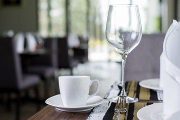 Reserved sign on a table in restaurant. Empty glasses set in restaurant