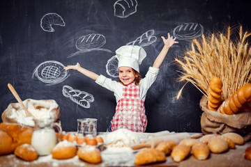 Charming girl wearing checkered apron with hat and standing with hands raised at table with cooking...